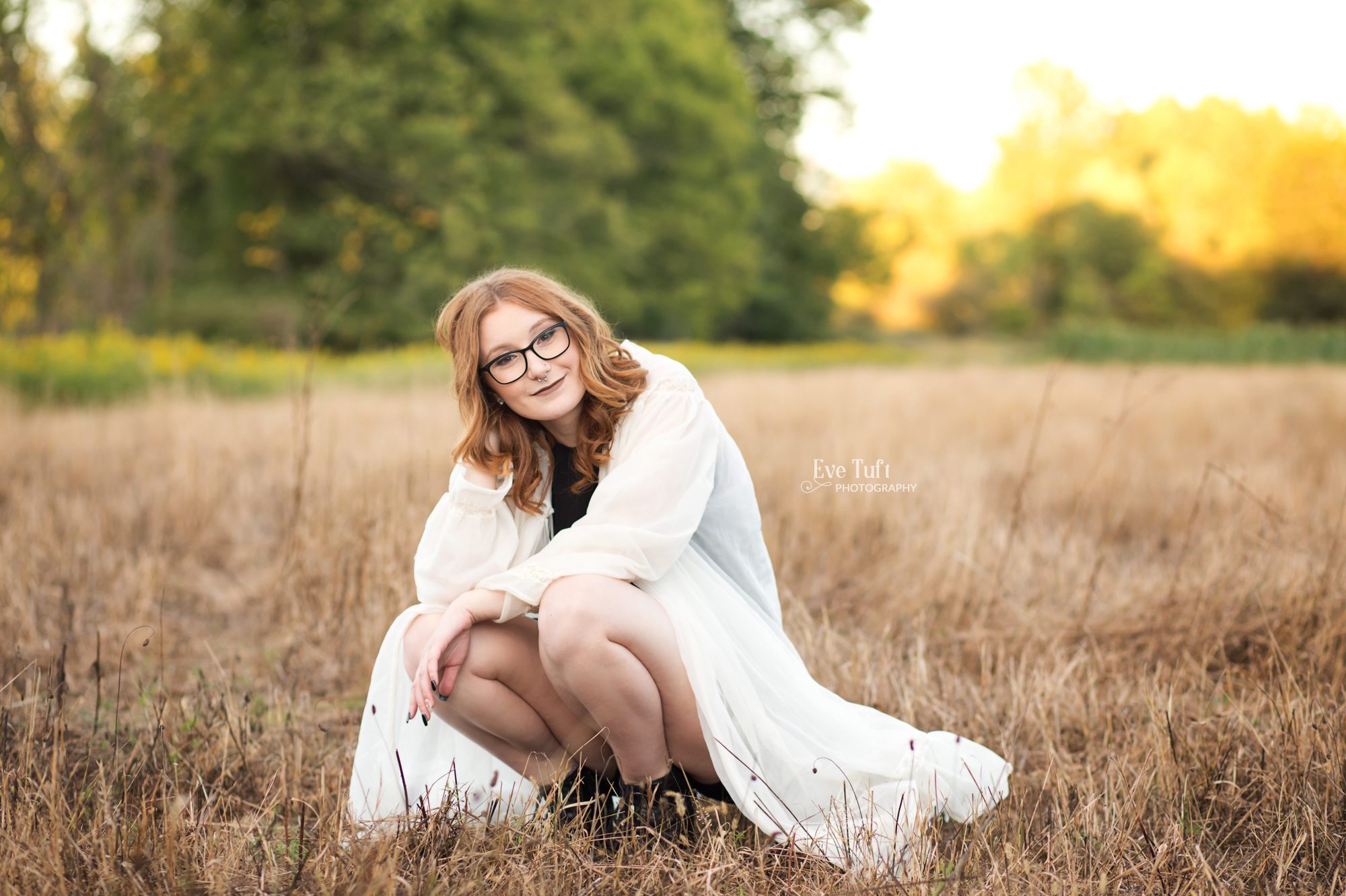 A beautiful teenager squats in fields at CNC in Midland, MI | Senior Photographer