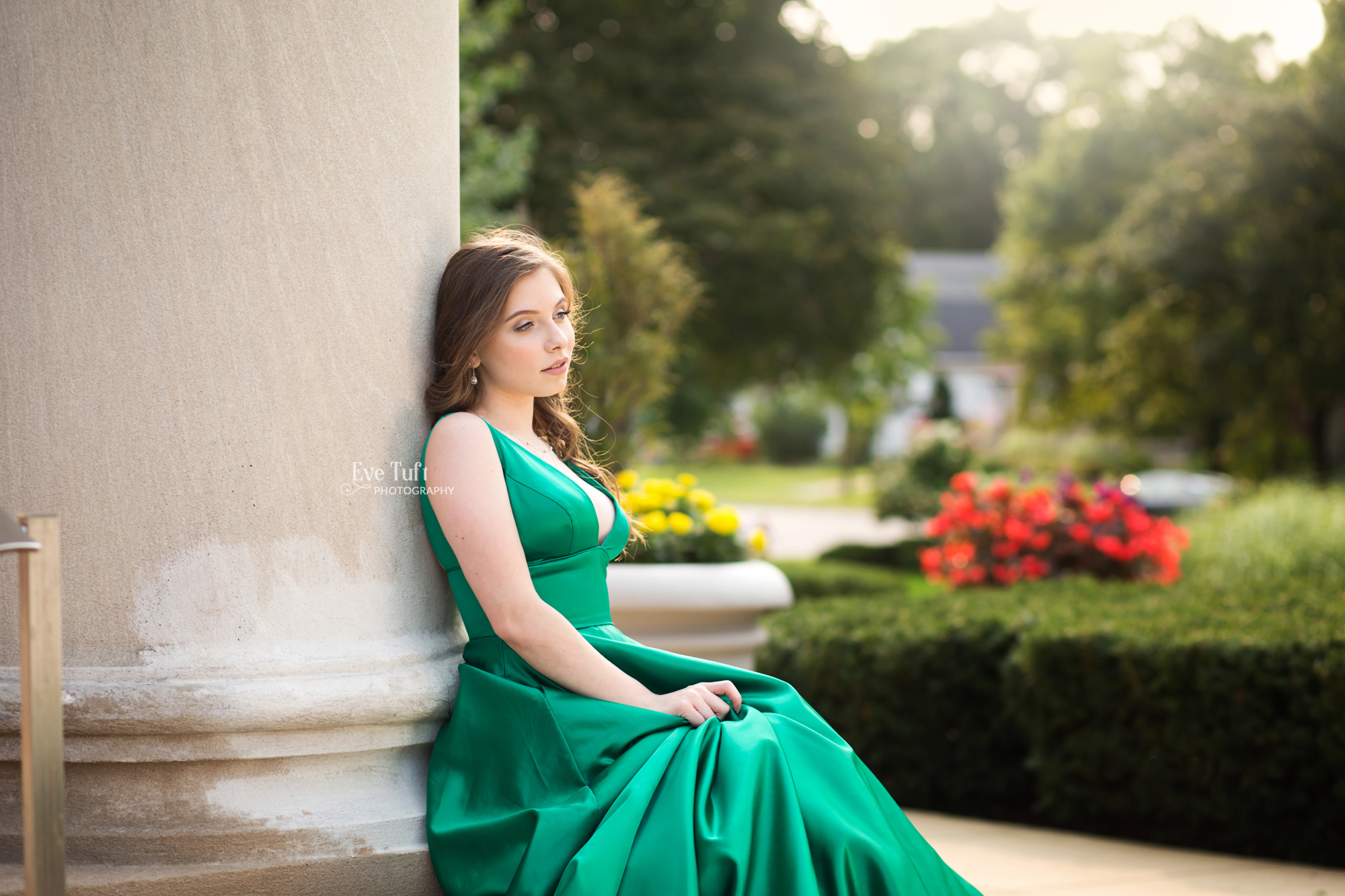 A girl in a green dress leans against a pillar ourtide at a church | Midland, MI senior photographer