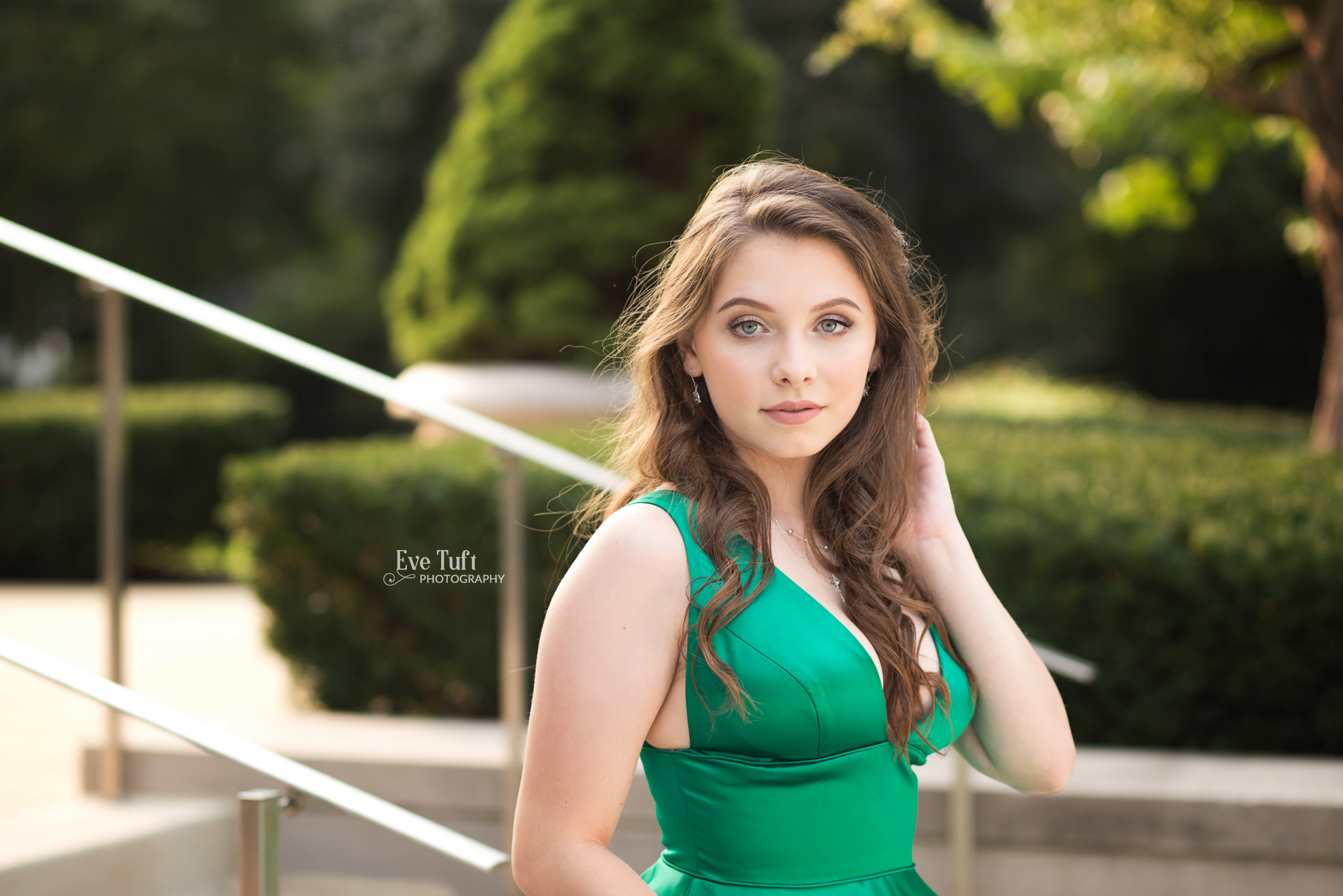 A teenager brushes her hair behind her ear in a green dress | Senior Photographers near me in Michigan