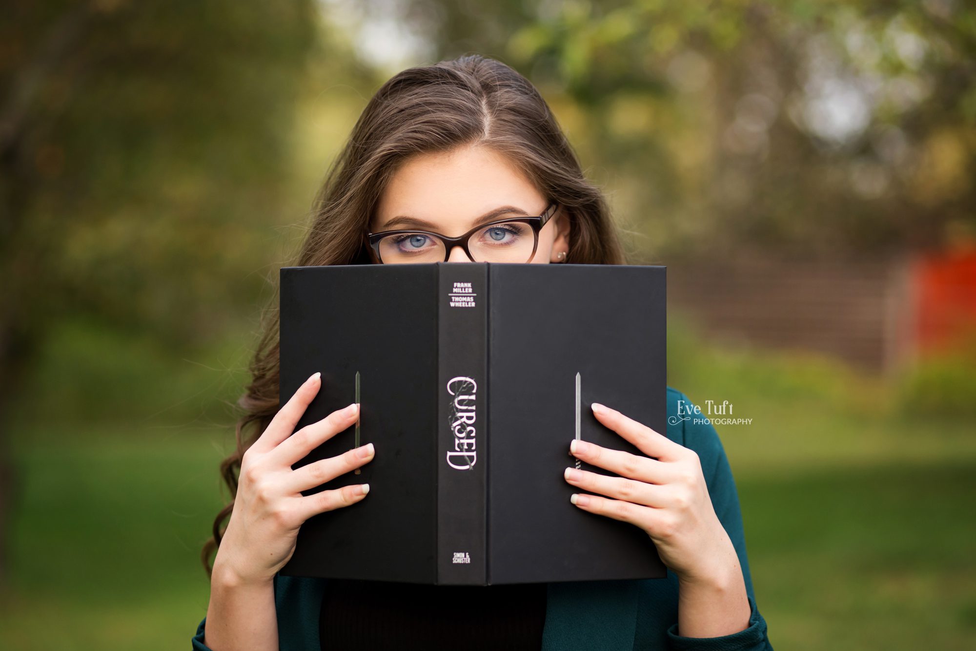A beautiful young woman peeks above a book | Midland, Michigan Senior Session