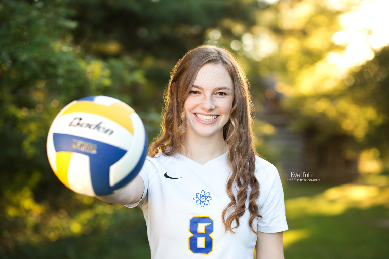 Midland High School volleyball player holding a ball outside at the Chippewa Nature Center | Best Senior Photographers in Midland, MI