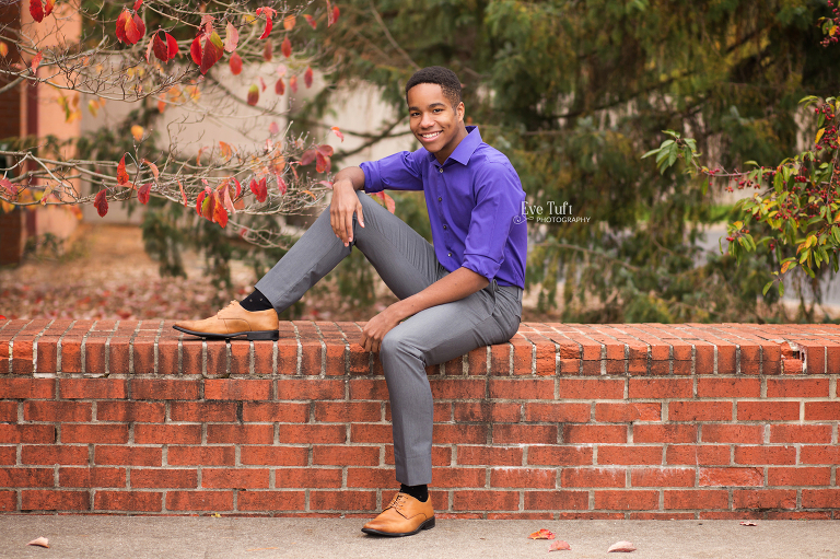 A young man sits on a brick wall near Dow Gardens for the last senior session of the year | Midland, MI senior Photographers