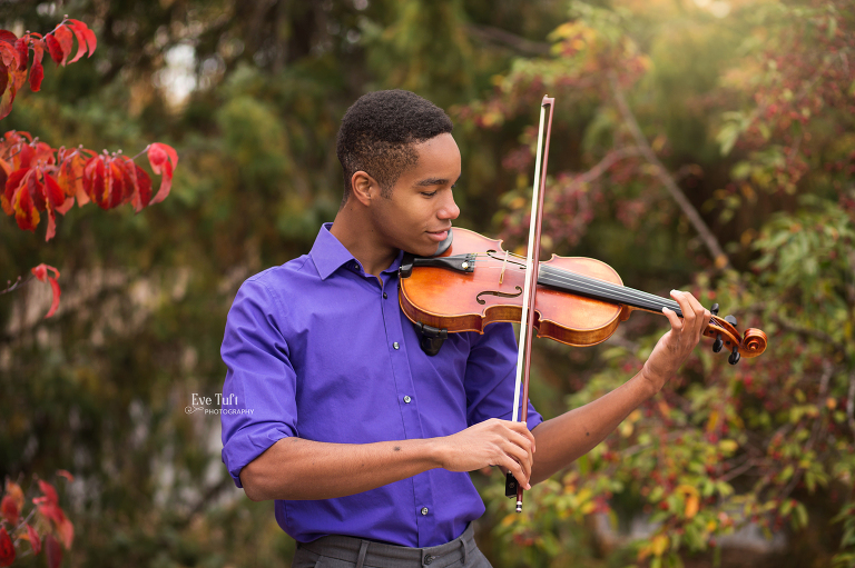 Teenage boy plays his violin outside in the fall | Senior Photographers in Midland, Michigan