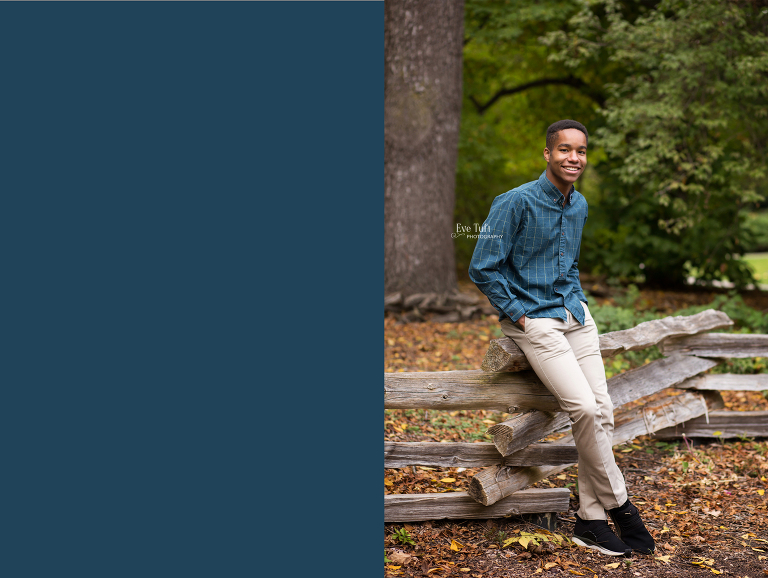 A handsome teen leans against a wooden fence outside at Dow Gardens | Senior Photographers in Midland, Michigan