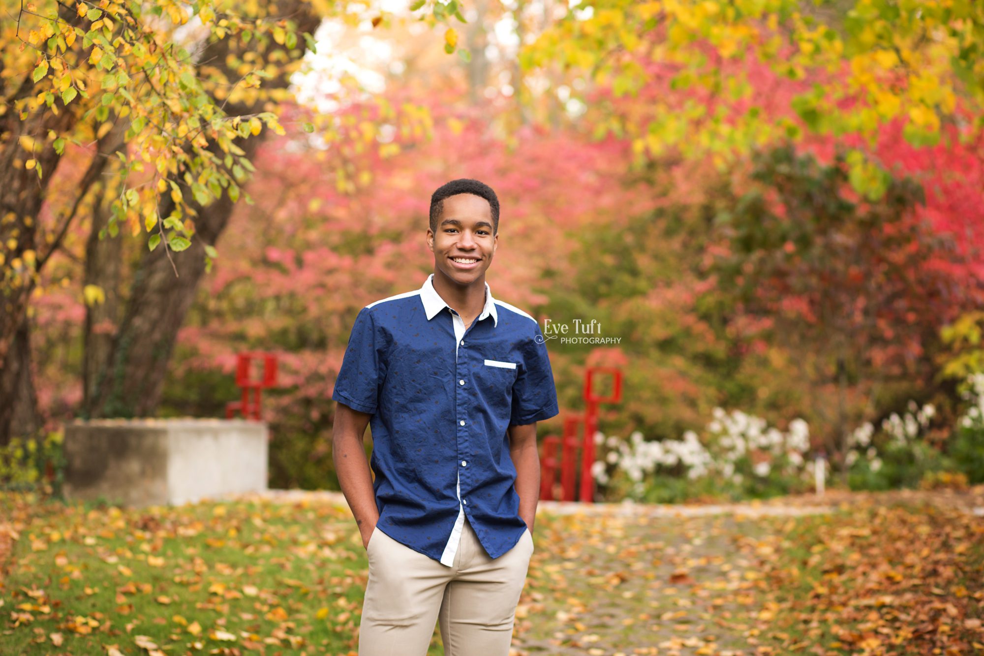 Beautiful fall foliage and a red bridge for a senior session outside with a teenager at Dow Gardens