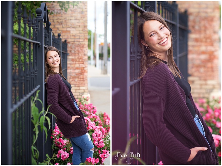 A beautiful senior girl leans against a wrought iron fence outside in Bay City | Michigan Senior Photographers