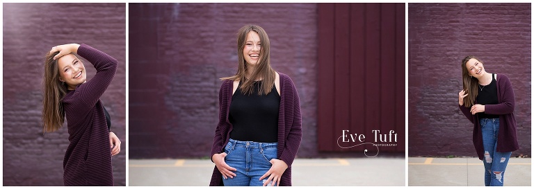 A senior girl laughs in front of a brick wall at Downtown Bay City | Michigan Senior Photographers