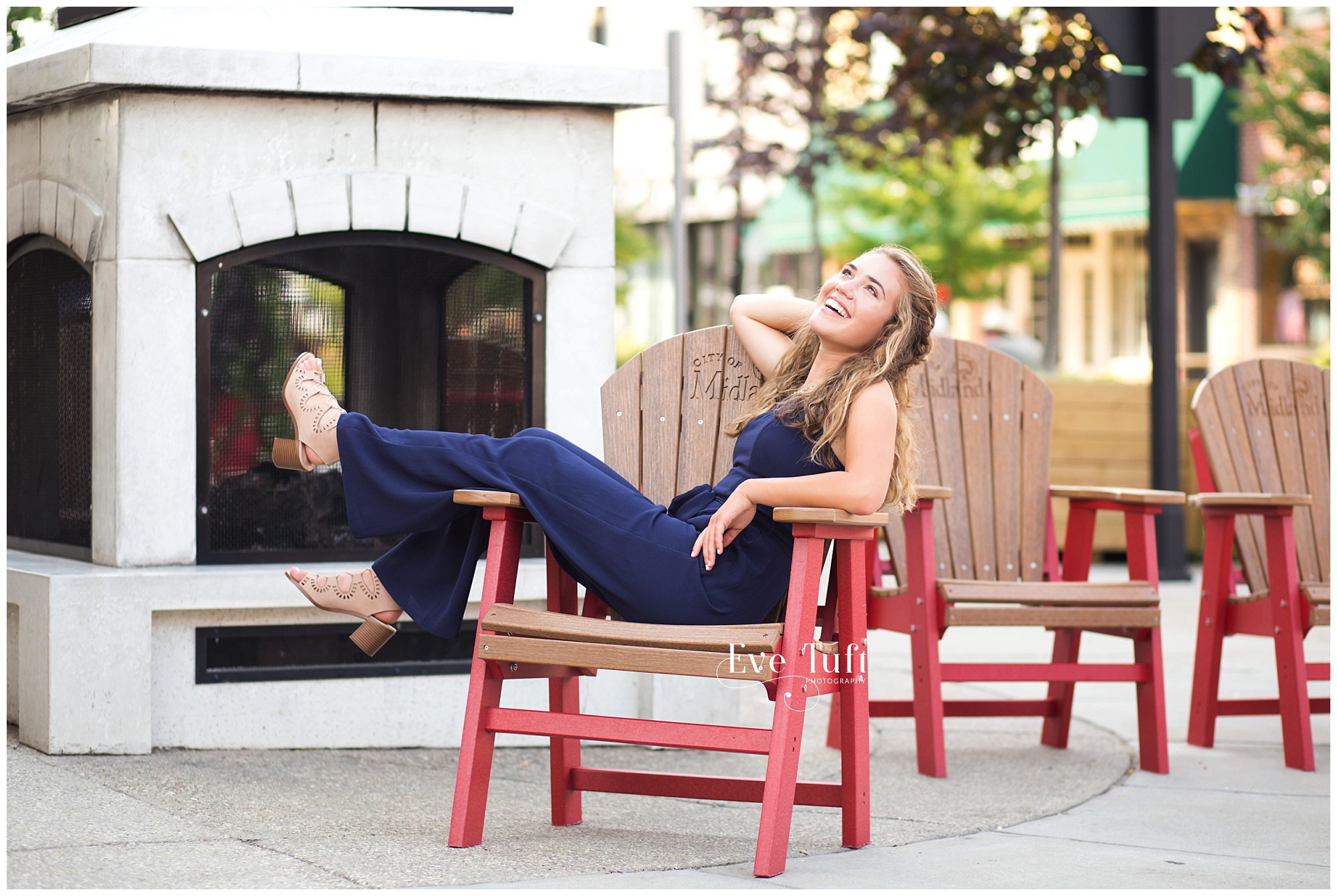 A senior leans back in a chair downtown | Midland, MI senior Photographer