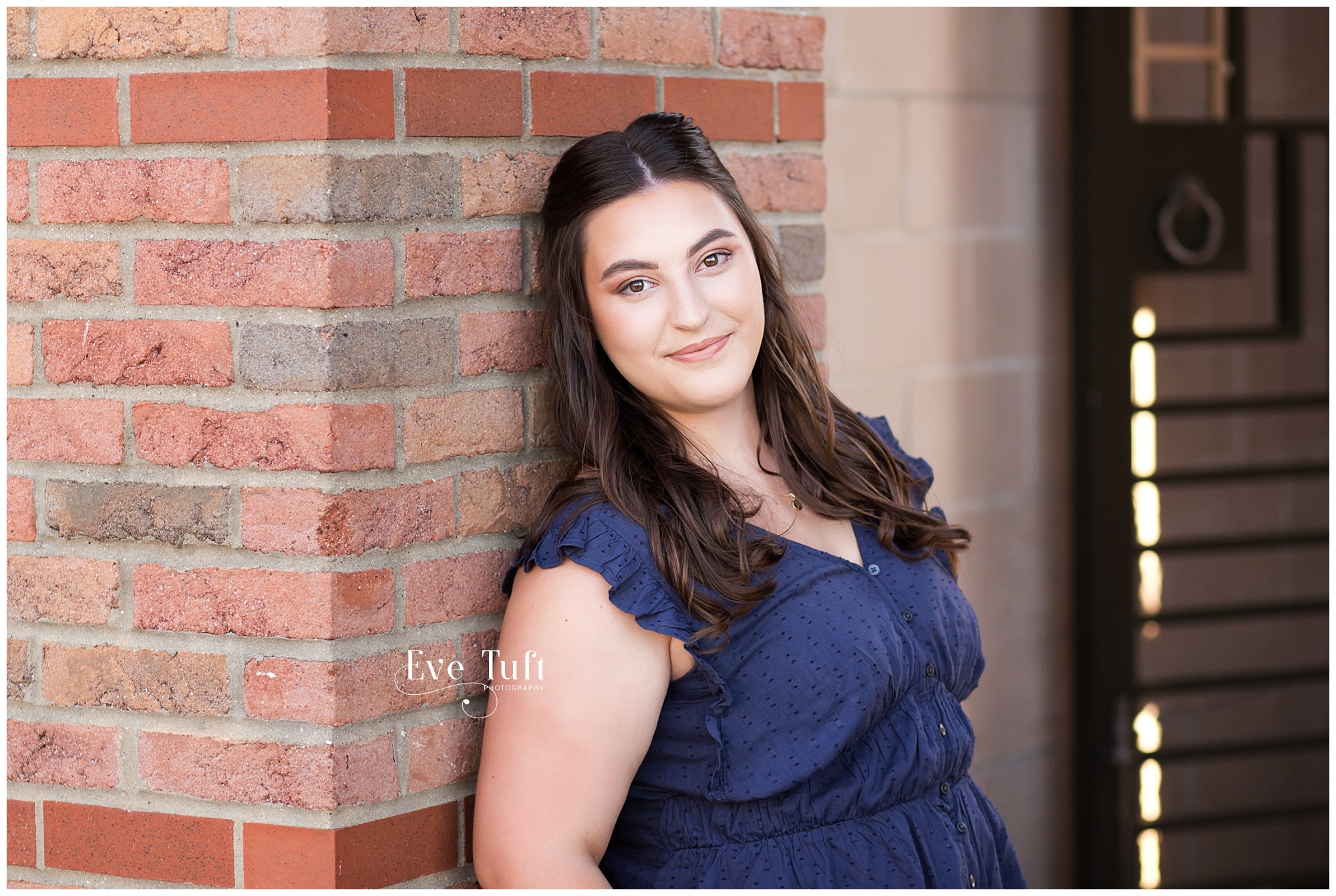 A simple and stunning young woman leans up against a brick wall outside | Midland, Michigan senior photographer