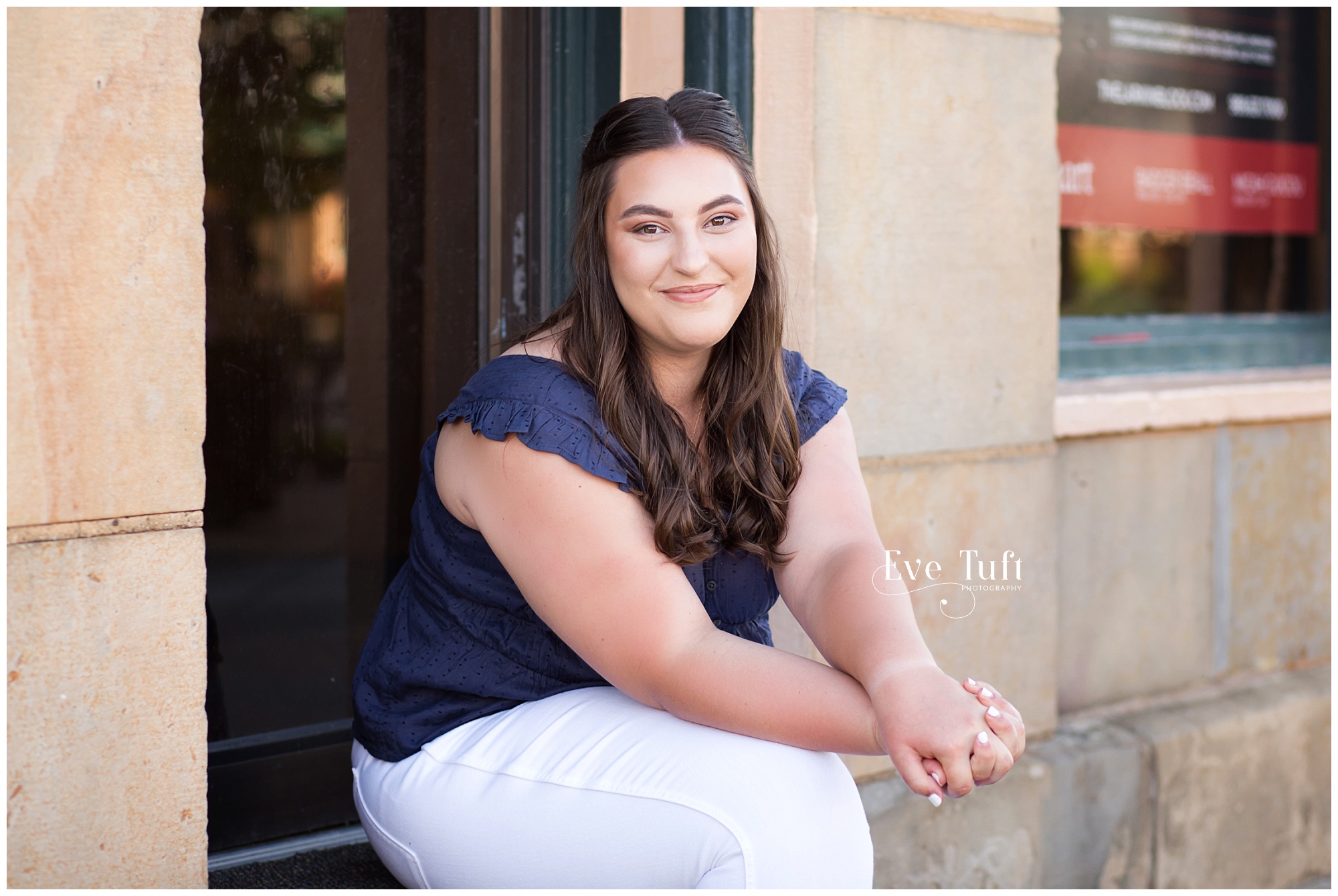 A young woman sits in a doorway for her session with Eve Tuft | Midland's Senior photographer