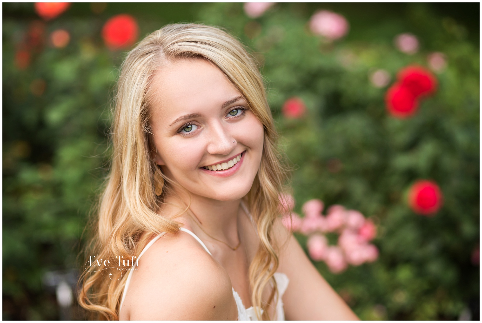 A teen sits among roses at Dow Gardens | Midland, MI Senior Photographers