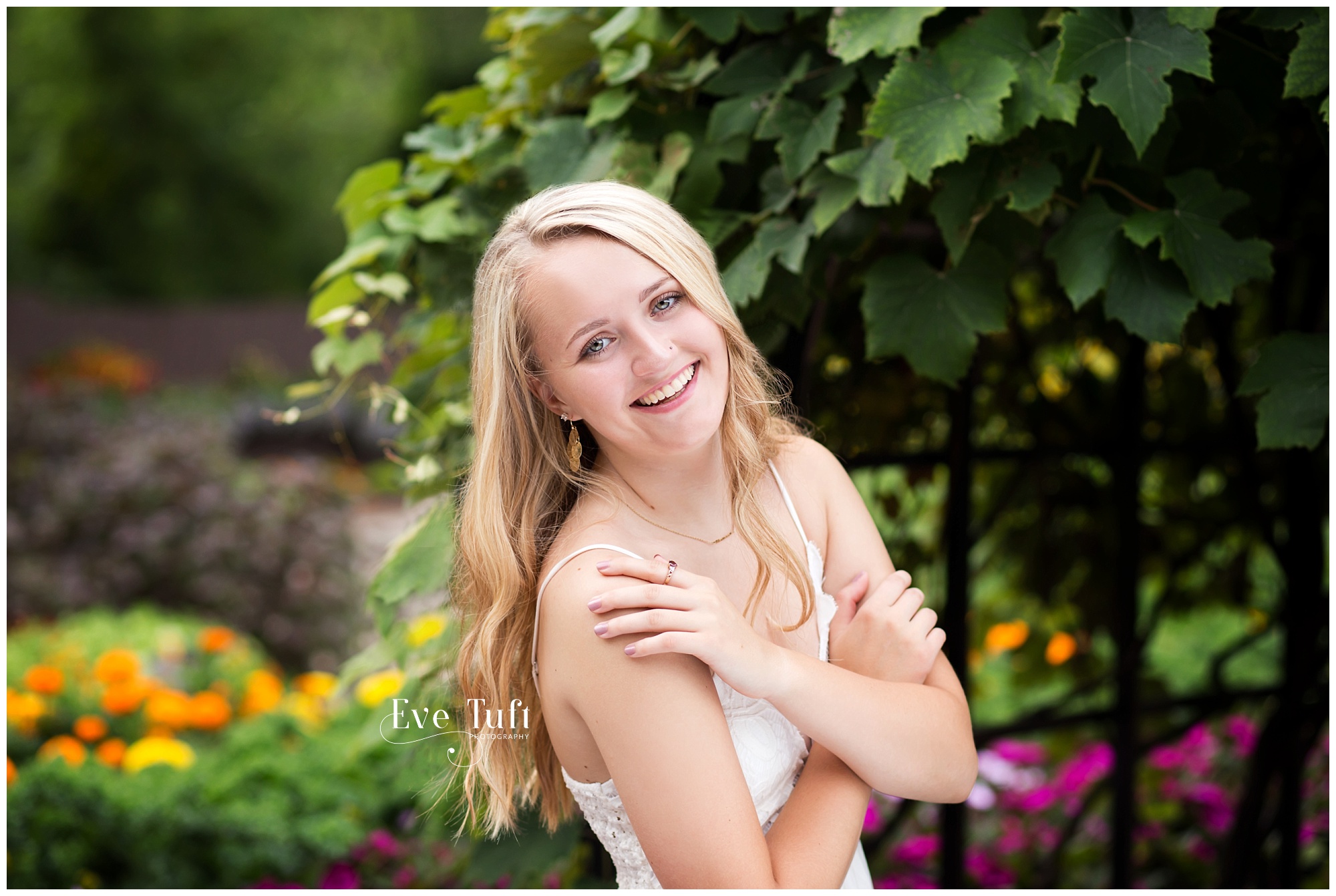 A beautiful girl poses near the grapevine and roses | Senior Photos in Midland, MI