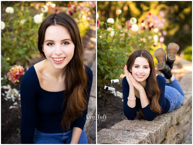 A teen sits on a rock wall outside with flowers all around her | Senior Photographer at Dahlia Hill in Michigan