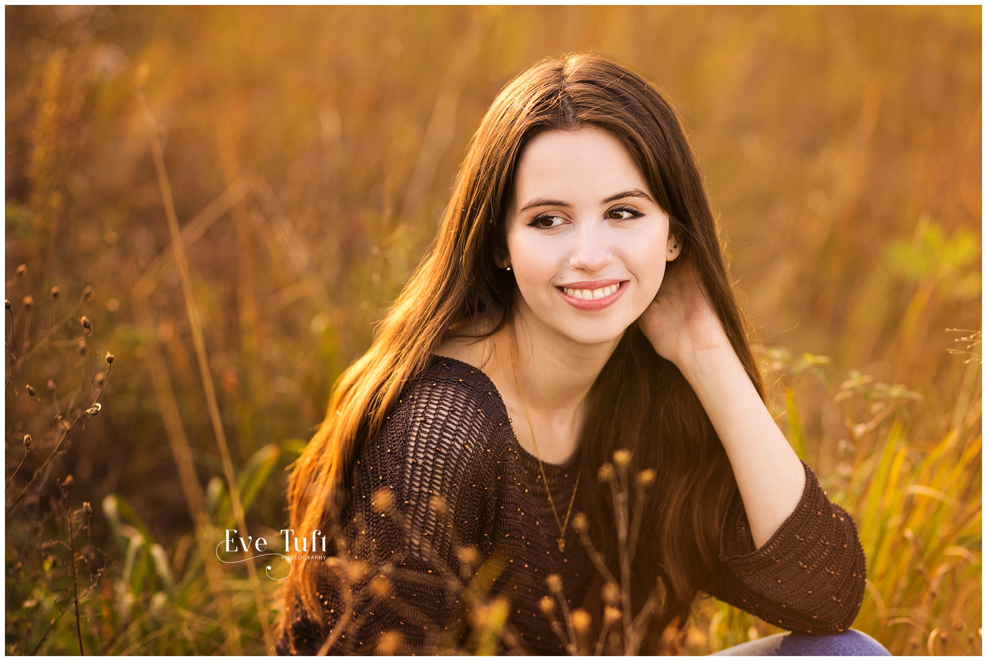 A beautiful teen sits outside in the grass in the fall | Midland, MI Senior Photography