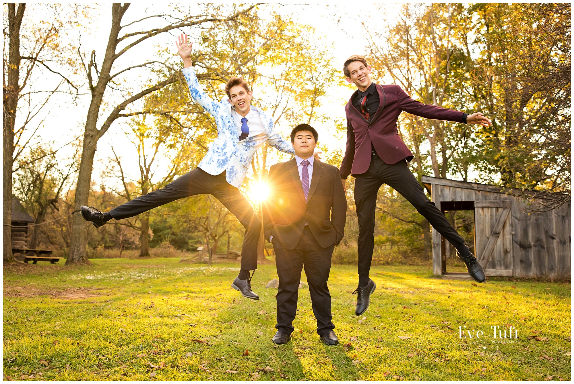Two guys jump in the air outside for their senior session | Midland, Michigan Photographers
