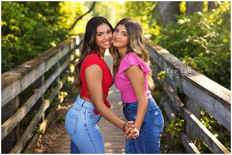 Two beautiful teens pose together outside on a bridge | Bay City Senior Photographer