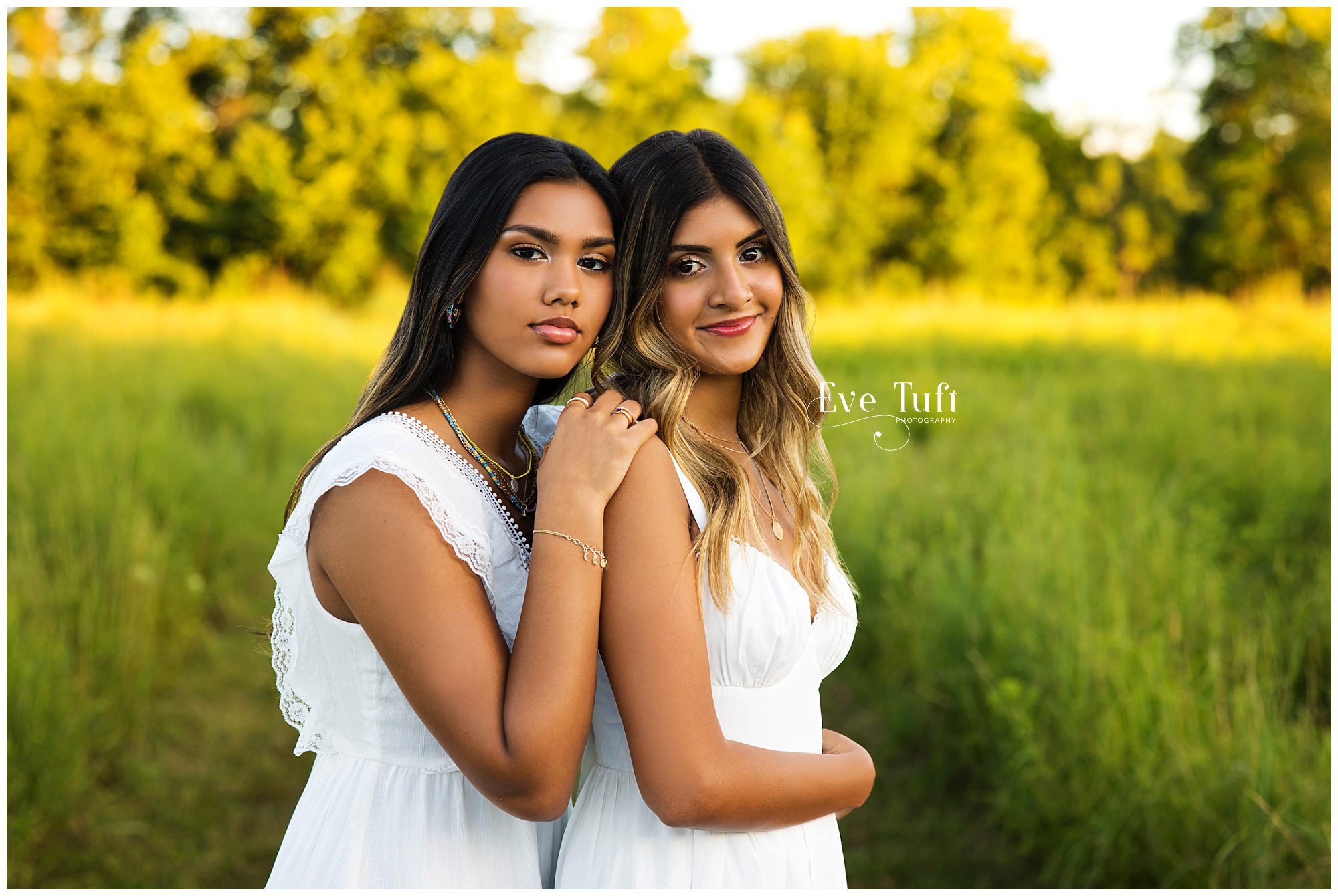 Tow lovely women wearing white dresses stand outside at the nature center | Midland, MI Senior Photographers